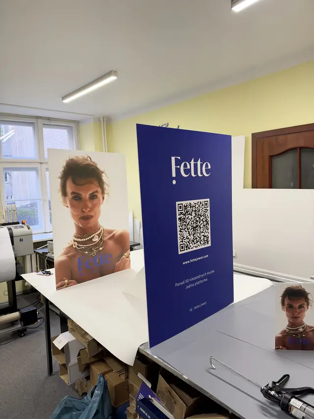 Dwa roll-upy z grafiką i kodem QR rozstawione w pracowni